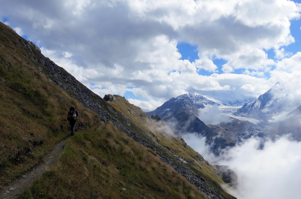 hiker on a Haute Route mountain trail in the Swiss Alps