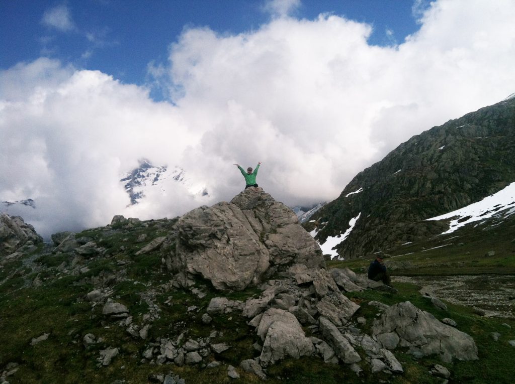 happy hiker on top of rocky outcrop in the Alps