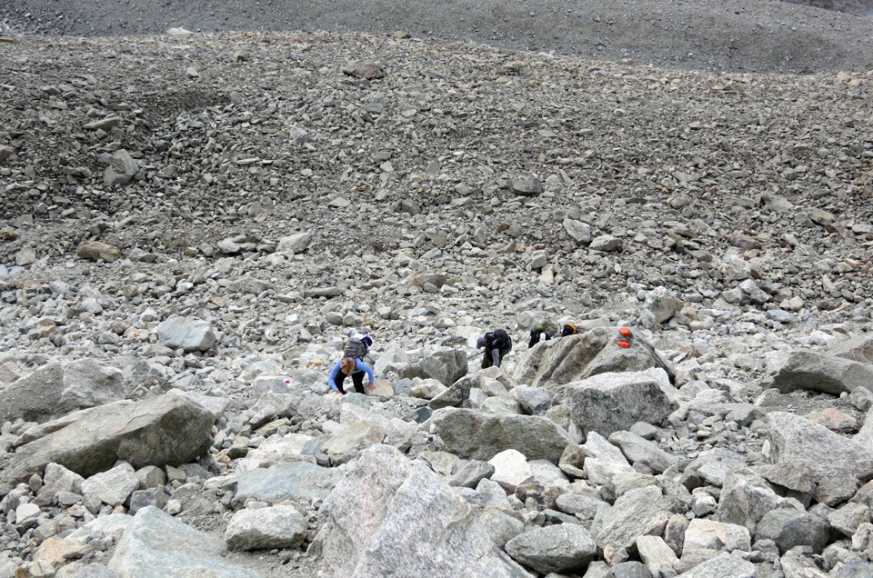 hikers scrambling over boulders Haute Route Pas de Chevre pass Alps