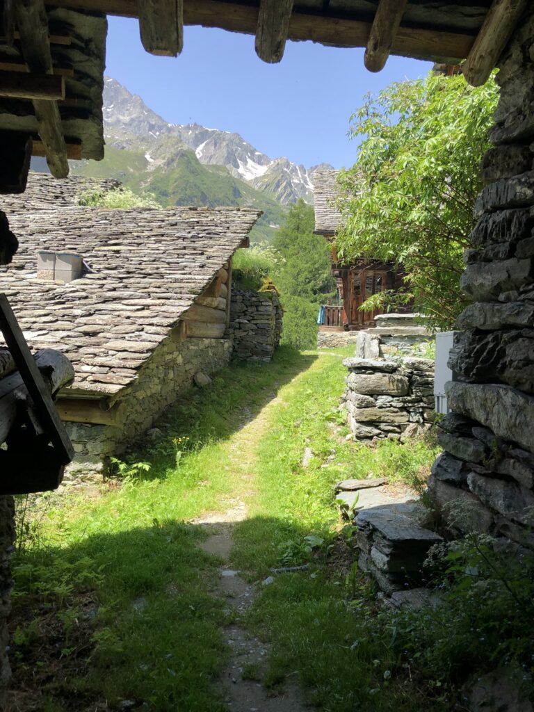 alps hiking trail through the stone buildings of Rifugio Pastore 