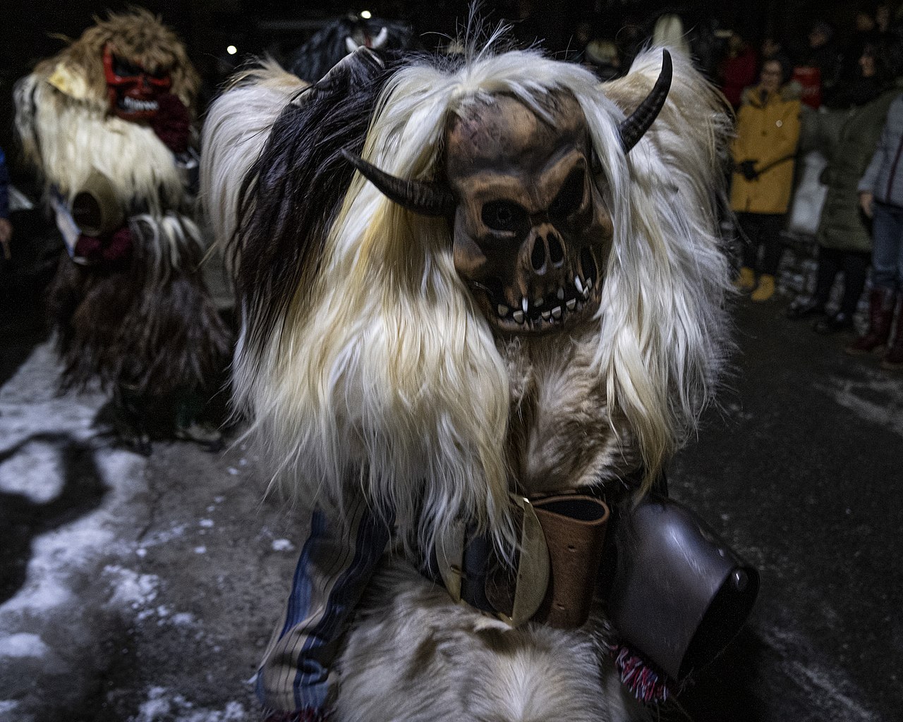 giant cowbell and scary mask pagan ritual Swiss Alps